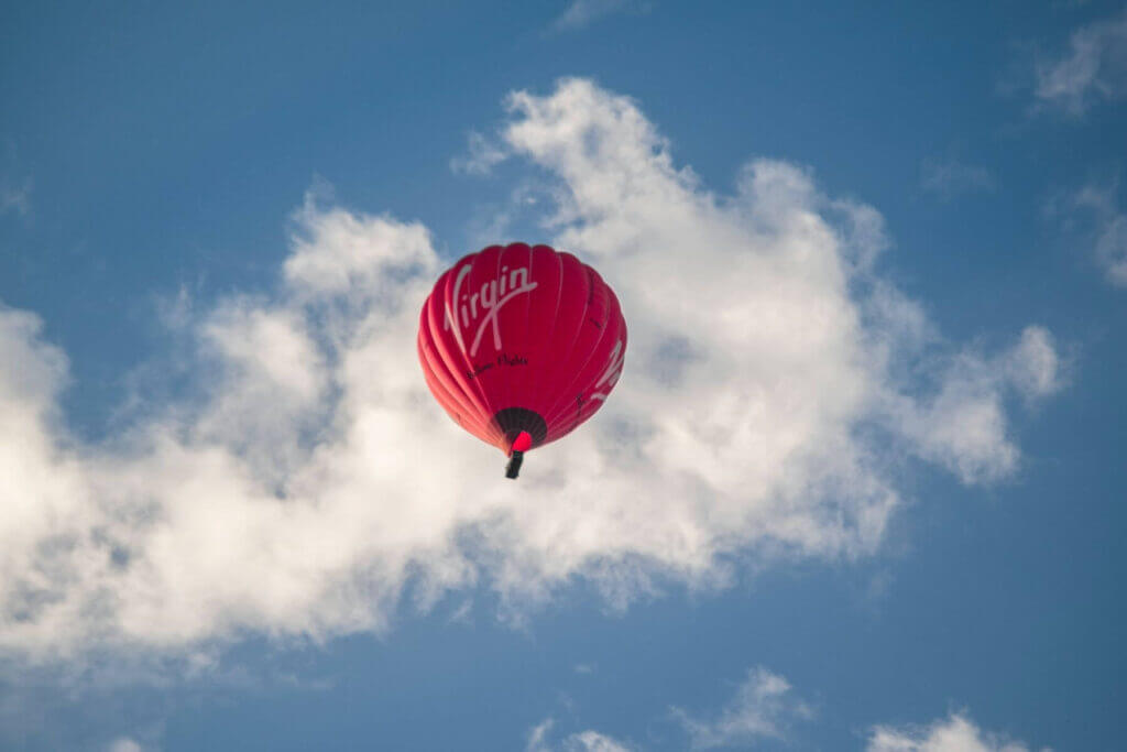 red virgin hot air ballon in blue sky